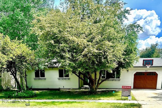 510 Flathead Ave, Bozeman, MT 59715 - view of property hidden behind natural elements with an attached garage, driveway, and a front yard