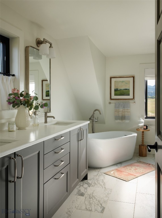 7980 Balsam, Bozeman, MT 59718 - full bathroom with plenty of natural light, a soaking tub, double vanity, and marble look tiles