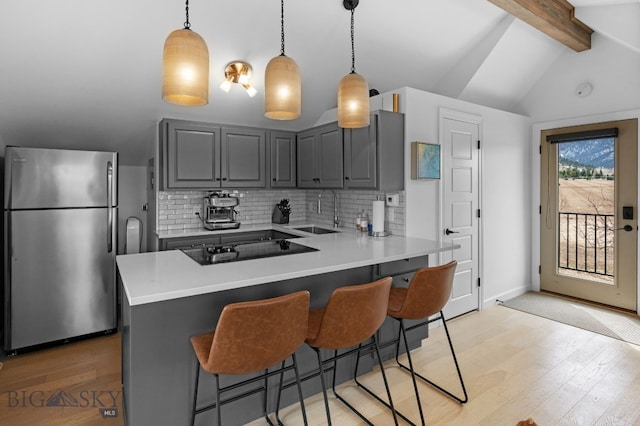 7980 Balsam, Bozeman, MT 59718 - kitchen featuring freestanding refrigerator, gray cabinets, black electric cooktop, decorative backsplash, and light wood-type flooring