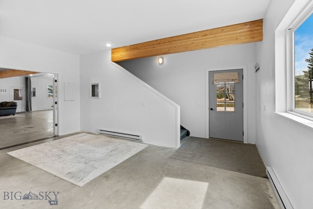 7980 Balsam, Bozeman, MT 59718 - unfurnished living room with a baseboard heating unit, finished concrete flooring, baseboard heating, stairway, and healthy amount of natural light