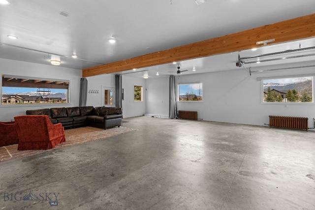 7980 Balsam, Bozeman, MT 59718 - living room featuring radiator, concrete floors, beam ceiling, and ceiling fan