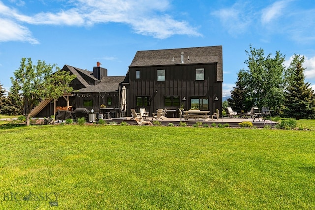 7980 Balsam, Bozeman, MT 59718 - back of property with board and batten siding, a yard, a patio area, and roof with shingles