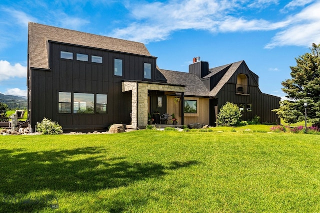 7980 Balsam, Bozeman, MT 59718 - rear view of house featuring board and batten siding, a yard, a shingled roof, and a chimney