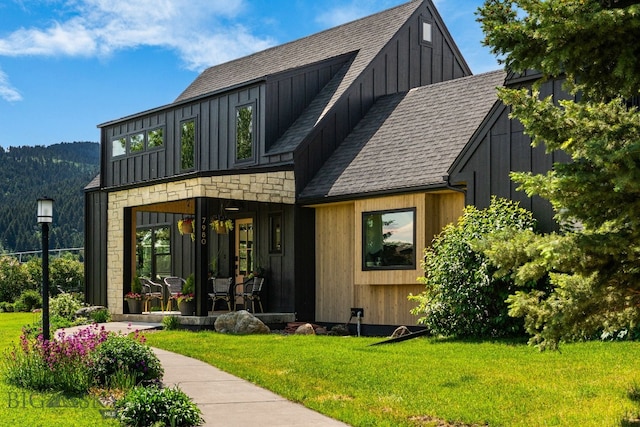 7980 Balsam, Bozeman, MT 59718 - view of front of house featuring board and batten siding, a front lawn, and a shingled roof