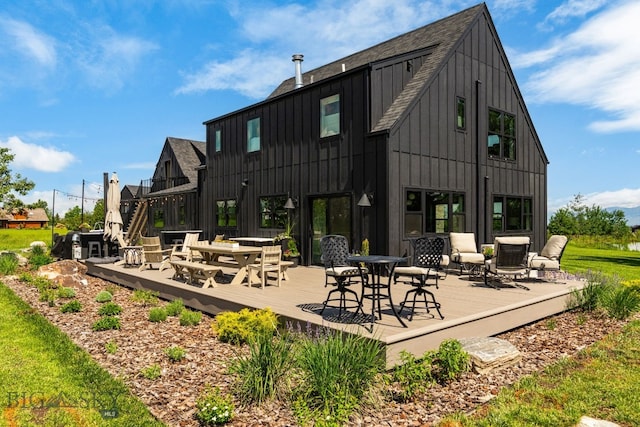 7980 Balsam, Bozeman, MT 59718 - rear view of property featuring board and batten siding, roof with shingles, a deck, and outdoor dining space