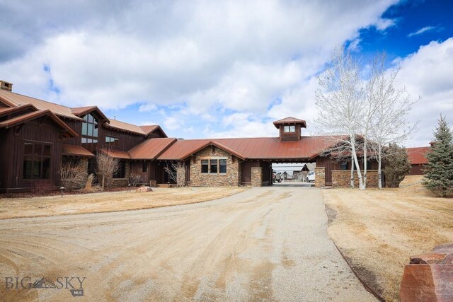 201 Cotton Willow, Melrose, MT 59743 - view of front of house with stone siding, metal roof, and dirt driveway