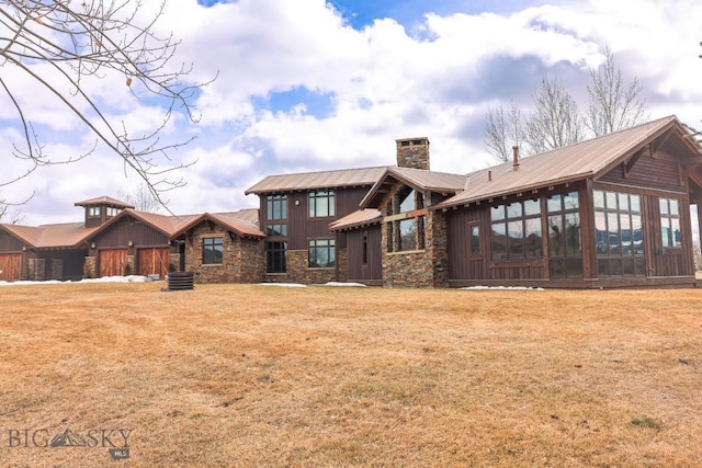 201 Cotton Willow, Melrose, MT 59743 - rear view of house with a chimney, stone siding, a sunroom, and metal roof