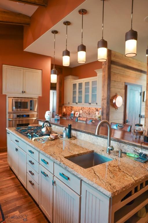 201 Cotton Willow, Melrose, MT 59743 - kitchen featuring a sink, appliances with stainless steel finishes, pendant lighting, wood finished floors, and light stone countertops