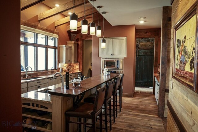 201 Cotton Willow, Melrose, MT 59743 - kitchen featuring a sink, stainless steel microwave, dark wood-style floors, and a breakfast bar area