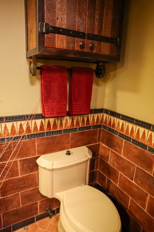 201 Cotton Willow, Melrose, MT 59743 - bathroom with toilet, tile walls, and wainscoting