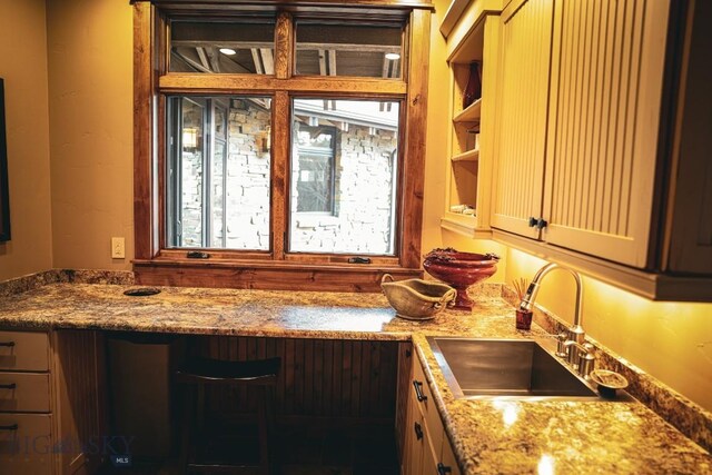 201 Cotton Willow, Melrose, MT 59743 - kitchen featuring a sink, light stone counters, and cream cabinets