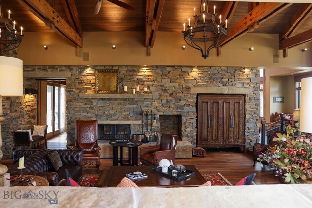 201 Cotton Willow, Melrose, MT 59743 - living room with a stone fireplace, wooden ceiling with exposed beams, a chandelier, wood finished floors, and a ceiling fan