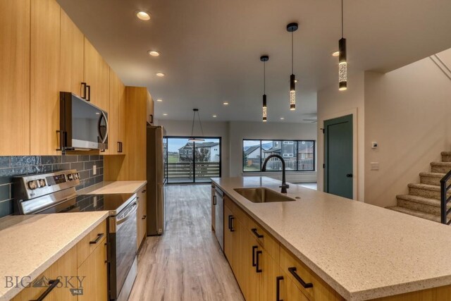 1104 Ridgeview Trl, Livingston, MT 59047 - kitchen with appliances with stainless steel finishes, modern cabinets, open floor plan, light stone countertops, and light wood-style flooring