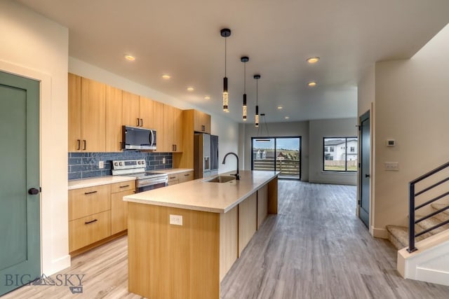 1104 Ridgeview Trl, Livingston, MT 59047 - kitchen featuring stainless steel appliances, light brown cabinets, modern cabinets, light wood-type flooring, and a kitchen island with sink