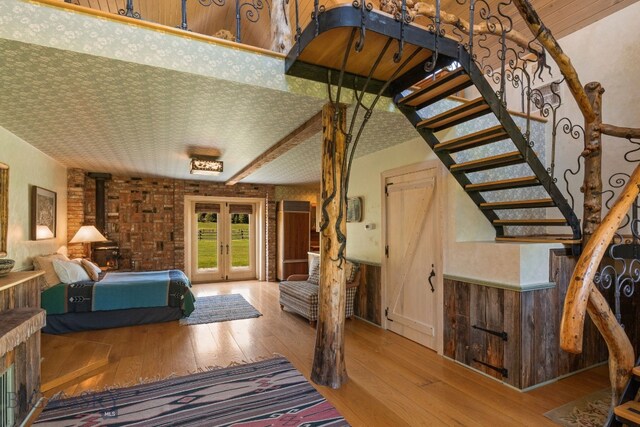 31255 Ninemile Rd, Huson, MT 59846 - bedroom with hardwood / wood-style flooring, french doors, access to outside, a wood stove, and wainscoting