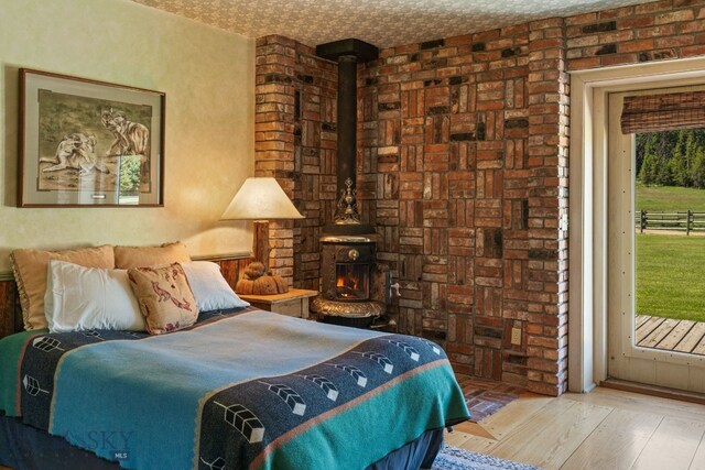31255 Ninemile Rd, Huson, MT 59846 - bedroom with access to outside, a wood stove, and wood finished floors