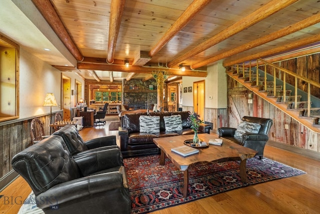 31255 Ninemile Rd, Huson, MT 59846 - living room featuring wooden walls, wood finished floors, wainscoting, stairway, and wooden ceiling with exposed beams