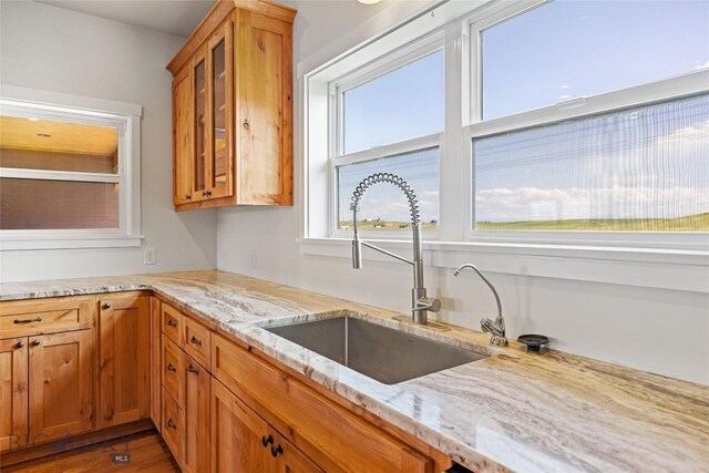 49 Wild Rye Pl, Three Forks, MT 59752 - kitchen featuring glass insert cabinets, light stone countertops, brown cabinets, and wood finished floors