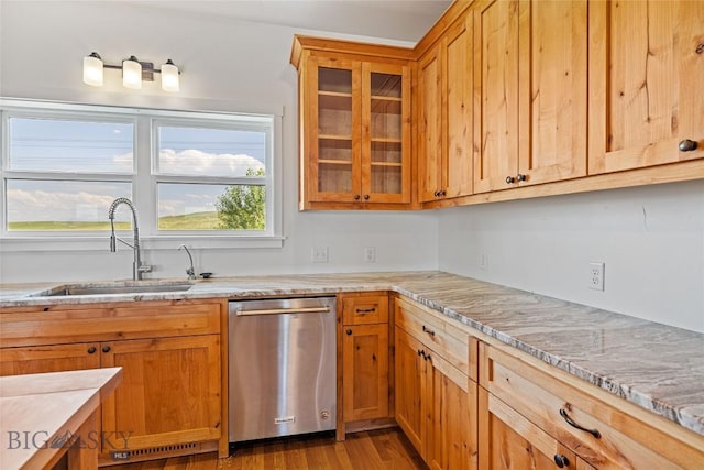 49 Wild Rye Pl, Three Forks, MT 59752 - kitchen with stainless steel dishwasher, glass insert cabinets, light stone counters, wood finished floors, and brown cabinetry