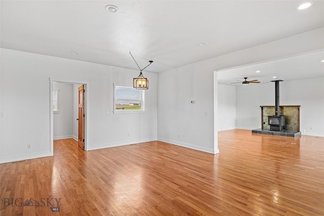 49 Wild Rye Pl, Three Forks, MT 59752 - unfurnished living room with light wood-type flooring, a wood stove, recessed lighting, and a ceiling fan