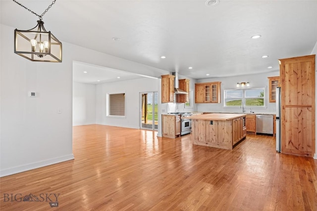 49 Wild Rye Pl, Three Forks, MT 59752 - kitchen with appliances with stainless steel finishes, wall chimney range hood, open floor plan, a kitchen island, and recessed lighting
