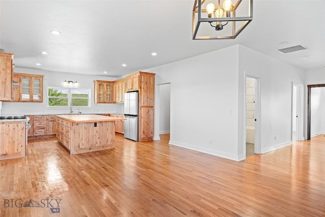 49 Wild Rye Pl, Three Forks, MT 59752 - kitchen featuring freestanding refrigerator, a kitchen island, light wood-style flooring, glass insert cabinets, and recessed lighting