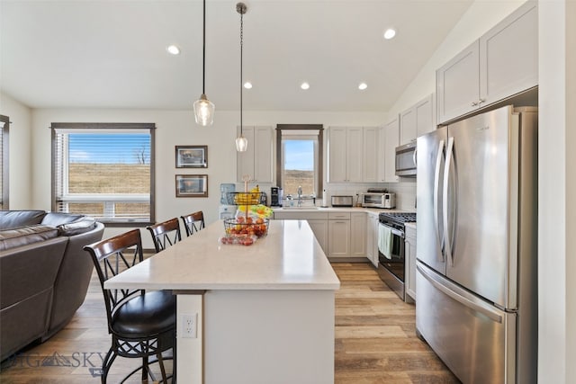 104 Albrey Trl Unit C, Bozeman, MT 59718 - kitchen featuring stainless steel appliances, open floor plan, a kitchen bar, a center island, and healthy amount of natural light