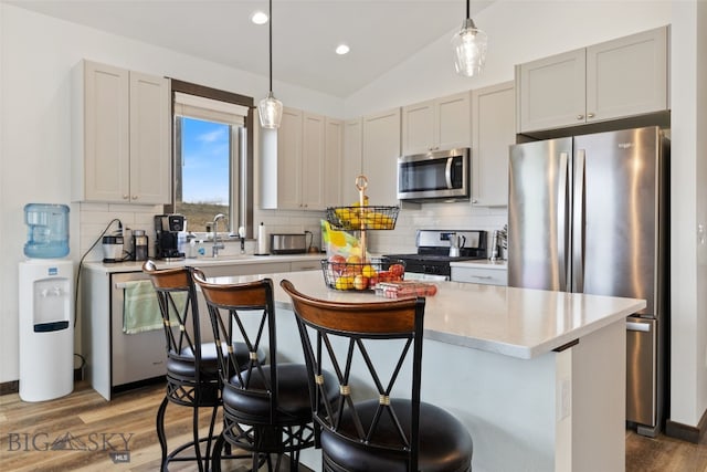 104 Albrey Trl Unit C, Bozeman, MT 59718 - kitchen featuring stainless steel appliances, wood finished floors, tasteful backsplash, a center island, and lofted ceiling