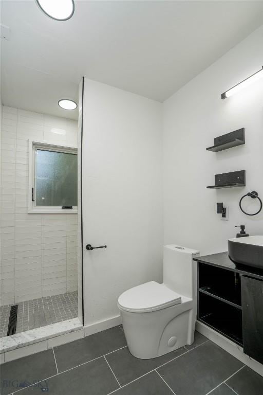 917 N 17th Ave Unit 3, Bozeman, MT 59715 - bathroom featuring tile patterned flooring, toilet, tiled shower, vanity, and baseboards