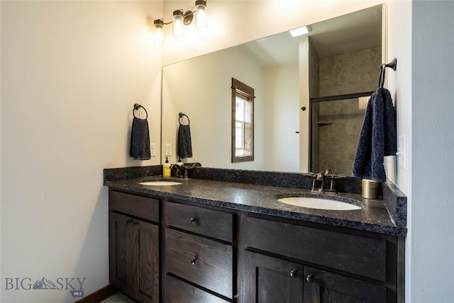 full bath with double vanity, an enclosed shower, and a sink