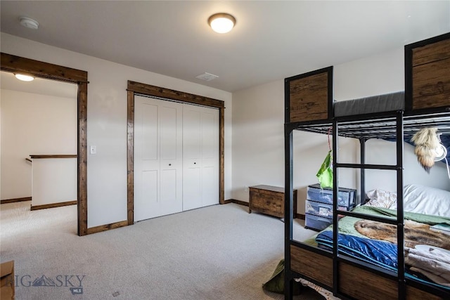 carpeted bedroom featuring baseboards, a closet, and visible vents
