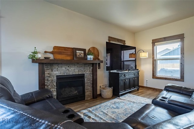 living area with baseboards, a fireplace, and wood finished floors