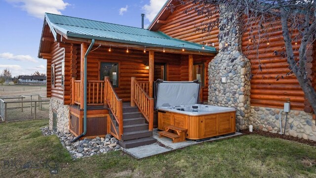 480 Moose Crossing Rd, Gallatin Gateway, MT 59730 - back of property with a hot tub, a metal roof, a lawn, and log exterior