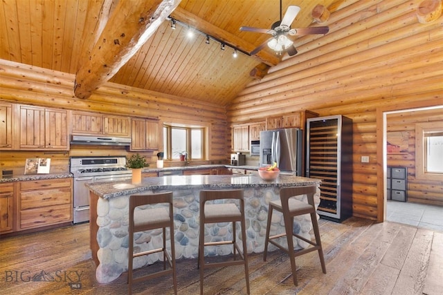 480 Moose Crossing Rd, Gallatin Gateway, MT 59730 - kitchen featuring appliances with stainless steel finishes, track lighting, beverage cooler, under cabinet range hood, and hardwood / wood-style floors