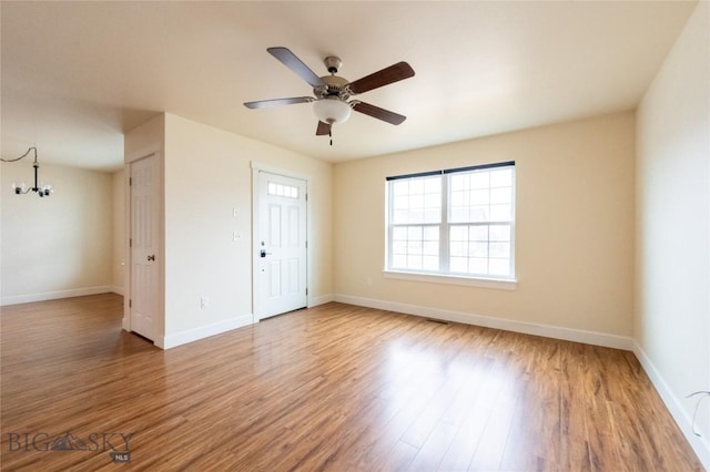 2300 Sturnella Ln, Belgrade, MT 59714 - unfurnished room featuring a chandelier, wood finished floors, baseboards, and a ceiling fan