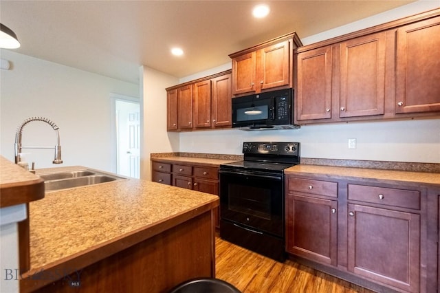 2300 Sturnella Ln, Belgrade, MT 59714 - kitchen featuring black appliances, a sink, light wood finished floors, light countertops, and recessed lighting