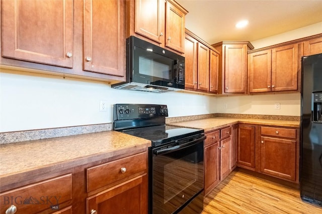 2300 Sturnella Ln, Belgrade, MT 59714 - kitchen featuring black appliances, light wood-style floors, light countertops, and brown cabinets