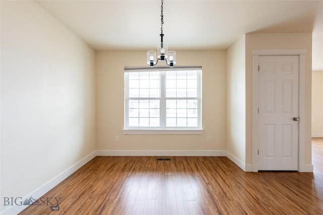 2300 Sturnella Ln, Belgrade, MT 59714 - empty room featuring a chandelier, baseboards, and wood finished floors
