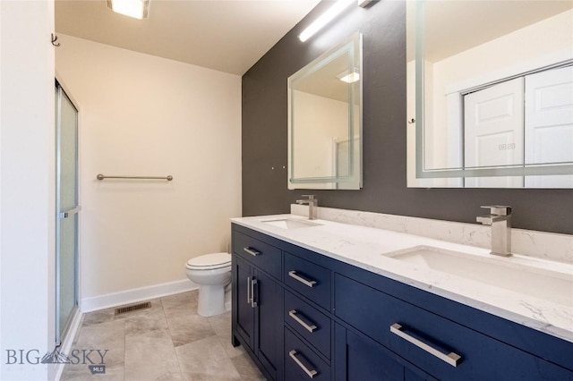 2300 Sturnella Ln, Belgrade, MT 59714 - bathroom featuring double vanity, toilet, baseboards, and a stall shower