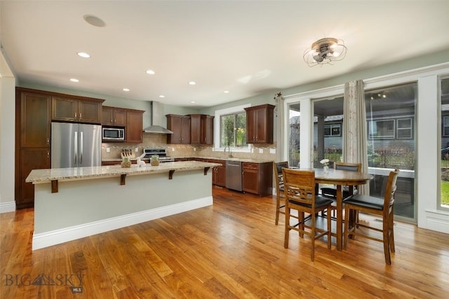 2026 Southbridge, Bozeman, MT 59718 - kitchen with appliances with stainless steel finishes, wall chimney exhaust hood, backsplash, a kitchen island, and recessed lighting