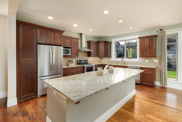 2026 Southbridge, Bozeman, MT 59718 - kitchen with stainless steel appliances, wall chimney range hood, a kitchen island, plenty of natural light, and recessed lighting