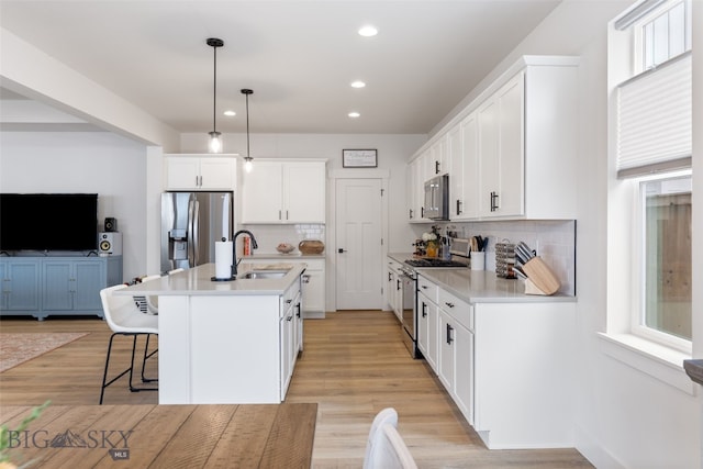1502 Cyril Way, Belgrade, MT 59714 - kitchen with stainless steel appliances, a sink, tasteful backsplash, a kitchen breakfast bar, and light countertops