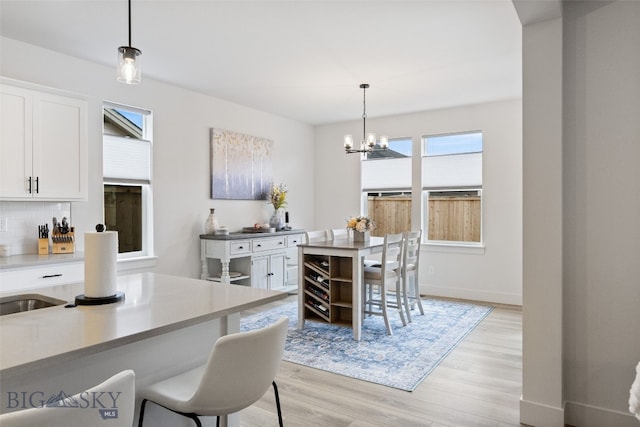 1502 Cyril Way, Belgrade, MT 59714 - dining room with light wood-style floors, a chandelier, and baseboards