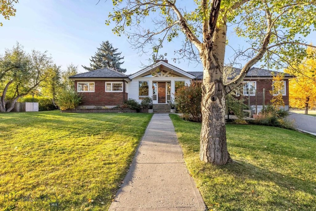 view of front facade with brick siding and a front lawn