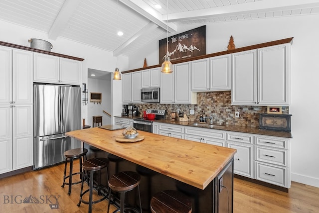 9 Blue Stem Way, Three Forks, MT 59752 - kitchen with stainless steel appliances, wood counters, a sink, light wood-style flooring, and decorative backsplash