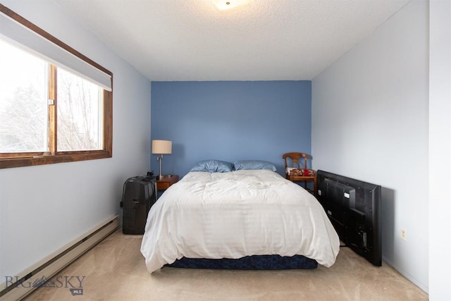 bedroom featuring light carpet, a textured ceiling, and baseboard heating