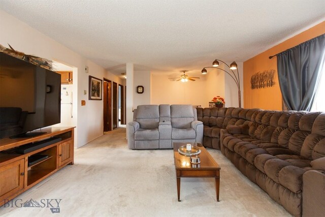 living room with light colored carpet, ceiling fan, and a textured ceiling