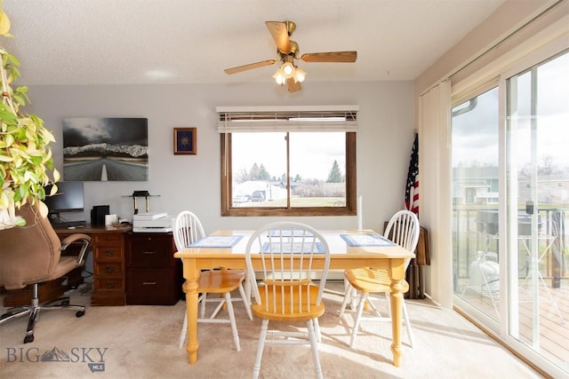 dining room featuring a textured ceiling, ceiling fan, light carpet, and plenty of natural light