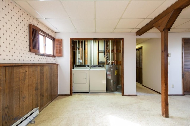 basement with a baseboard radiator, light carpet, electric water heater, separate washer and dryer, and a paneled ceiling