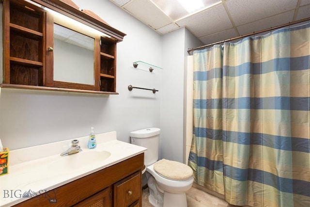 bathroom featuring toilet, a drop ceiling, vanity, and a shower with curtain